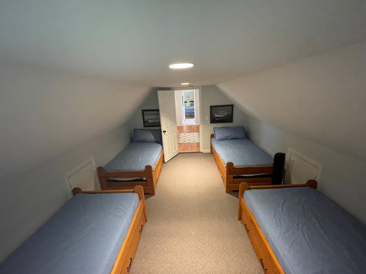 Спалня на горния етаж с четири единични легла, голямо чекмедже за съхранение под леглата
