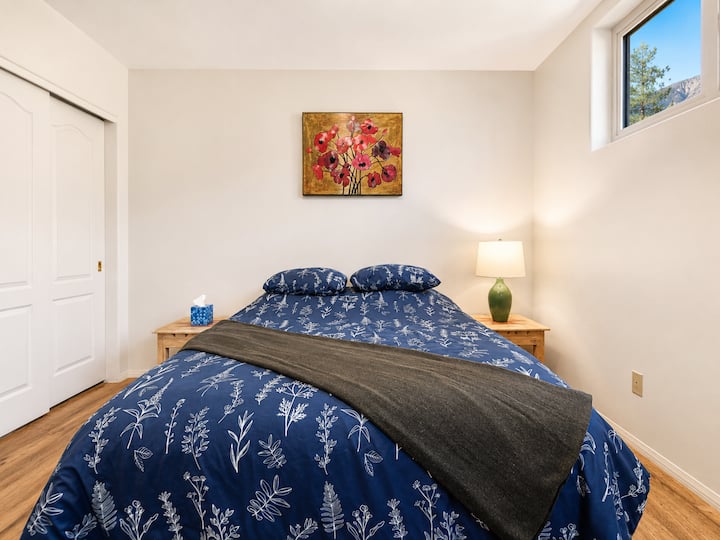 Svijetla druga spavaća soba s noćnim svjetlom, komodom za odlaganje i stropnim ventilatorom.