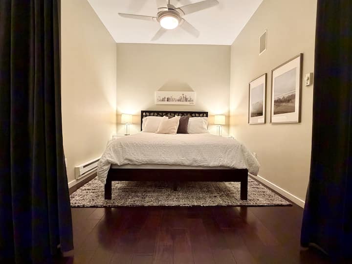 La cama tamaño queen se encuentra en un dormitorio abierto semiprivado ubicado en el extremo más alejado del condominio.  Para ayudar a bloquear la luz y el sonido, tiene cortinas de terciopelo del piso al techo que se cierran por completo.