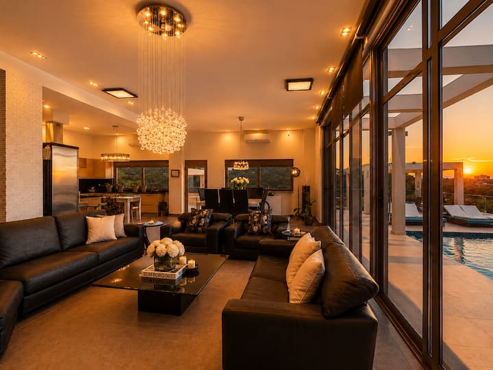 Main Level - Spacious open-plan living & dining area with floor-to-ceiling windows, breathtaking panoramic sea views, and direct access to the pool terrace