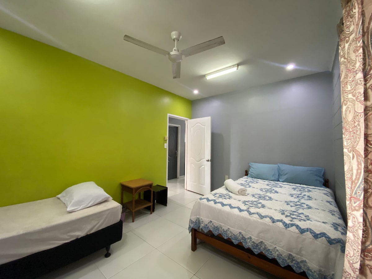 ห้องนอน 2 พร้อมเตียงควีนไซส์และเตียงเดี่ยวรวมถึงพัดลม