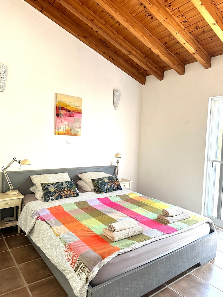 เตียงคิงไซส์พร้อมตู้เสื้อผ้ากว้างขวางในห้องสวีทพร้อมโต๊ะทำงาน