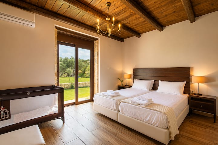 Bedroom 3 with two single beds (convertible into a king-size bed), a sofa bed, a baby cot, and direct access to the garden.