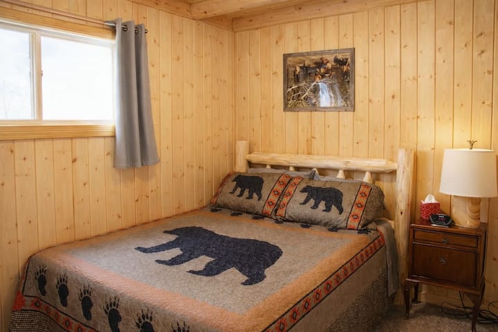 Cozy cabin bedroom with comfortable queen bed — perfect for restful nights after Yellowstone adventures