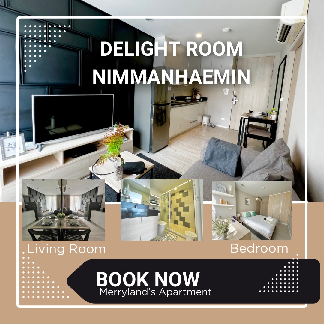 A well-furnished living area features a plush couch and a large, flat-screen smart TV. The kitchenette is equipped with modern appliances, and a dining table sits nearby. The bedroom area is visible, showcasing a comfortable bed against a stylish backdrop.