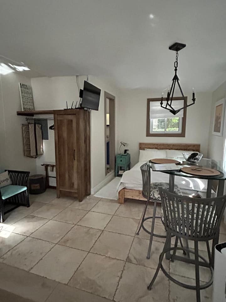 חדר שינה נעים עם מיטת קווין סייז ושידה.