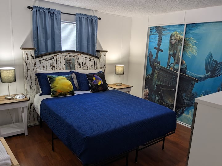 El dormitorio principal cuenta con una cama tamaño queen con una encantadora decoración náutica