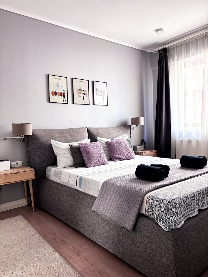 Paredes pastel suaves, una cómoda cama gris y toques inspirados en los viajes para desencadenar tu próxima aventura. Advertencia: la cama es tan acogedora que es posible que nunca quieras irte.