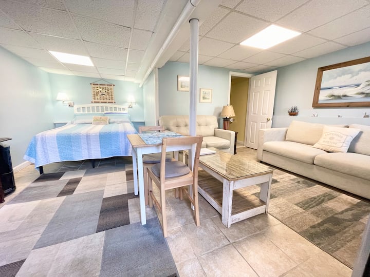 The studio with queen bed, sofa , table and bathroom.