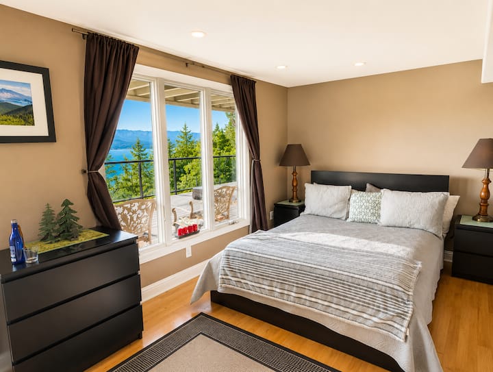 Open downstairs sleeping area with two queen beds. This space is accessed by the spiral staircase from the main level and does not have a private bedroom door.