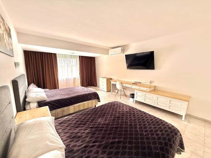 Master bedroom with two double beds, Smart TV and desk
