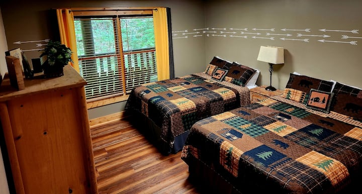 Spálňa na nižšom poschodí s 2 manželskými posteľami a televízorom