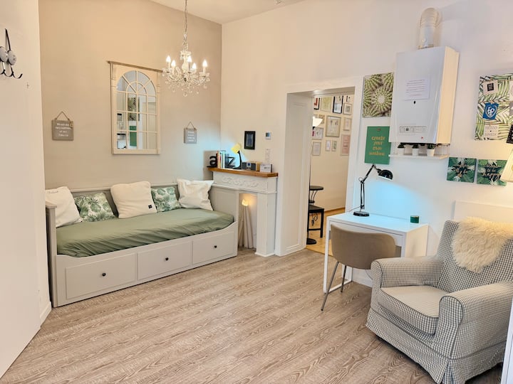 在餐厅厨房的一个区域，有一张舒适的阅读椅、一张带书桌椅的书桌、一个装饰壁炉和一张日光床