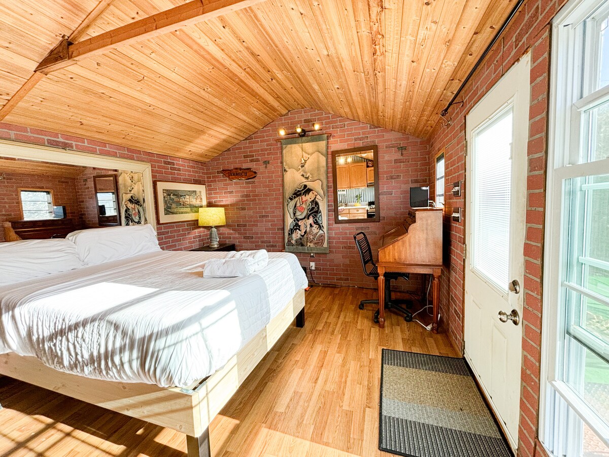 An open loft style cabin with a queen size bed made up for sleeping. A versatile space: sleeping, desk/chair-working, full kitchen for cooking. Bring robes, flip-flops to enjoy the hot tub, pool (seasonal) outdoor shower and detached full bathroom.
