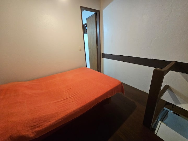 Habitación en el entrepiso con baño privado, cama matrimonial y ventilador de techo