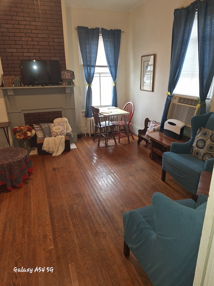 Sehemu kubwa ya sebule iliyo na sakafu za asili za mbao ngumu.