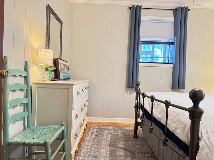 Main bedroom has double bed, view of the lake, dresser, and closet