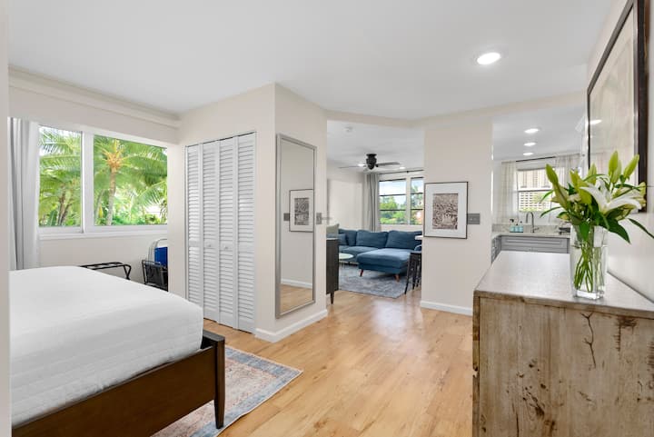 PRIMARY BEDROOM: Loft-style bedroom "open" to the living room and kitchen. Features a king bed, louvered closet, full-length mirror and large window with tropical views. Bedroom 2 is down the hallway (past the kitchen) and has a door for privacy.