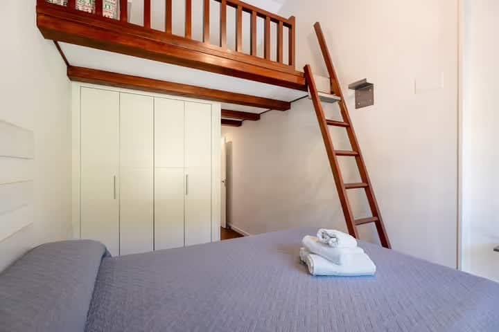 Acogedor dormitorio con cama doble, techos de madera y altillo con escalera, ideal para aprovechar el espacio y crear un ambiente cálido. Dispone de un gran armario empotrado y luz natural, perfecto para descansar con total comodidad.