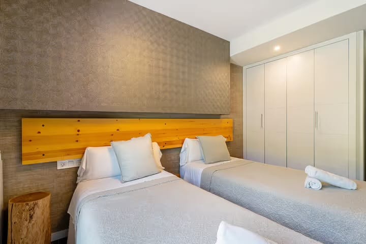Habitación con dos camas individuales, armario amplio y detalles en madera que aportan calidez. Perfecta para descansar después de un día en la naturaleza o compartir en familia con total comodidad.