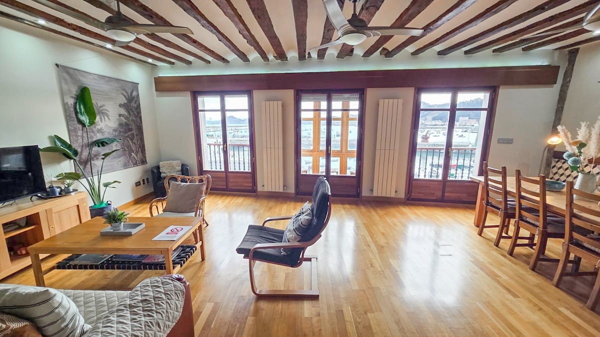 Salón comedor con vistas al puerto con un mirador donde podrás sentarte para disfrutar de las maravillosas vitas que tiene.