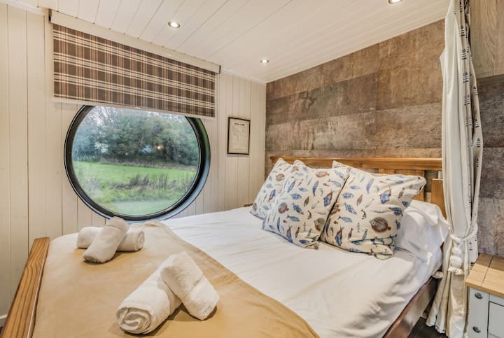 Wake to field views through the porthole in this snug fish-themed double bedroom.