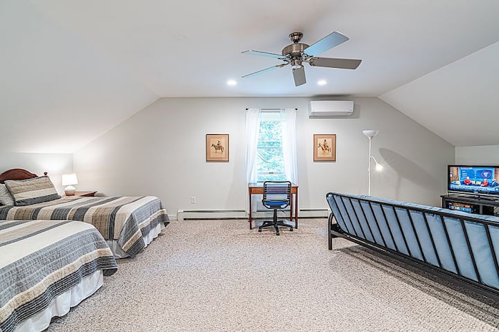 Голема спална соба на горниот кат со биро и стол