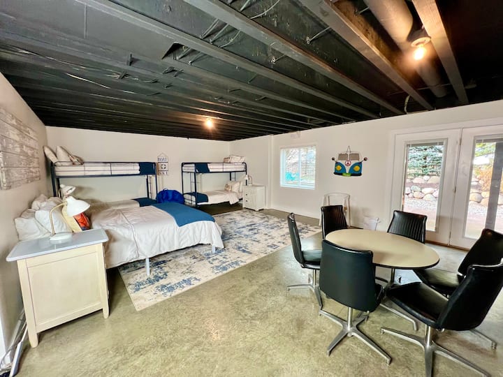 BASEMENT/GAME ROOM: Sleeps 6: 1 queen bed & 2 double bunks. Ping Pong, meza ya bwawa na meza ya mchezo/viti havijaonyeshwa. Toka nje ya milango ya baraza inayoteleza kwenda kwenye baraza la shimo la moto la nje. Viango vingi vya nguo na vyombo vya mapambo katika ukumbi wa karibu. Bafu kamili kwenye kiwango sawa