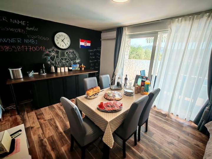 Sala de estar principal y comedor con mi número de teléfono para el contacto y el código wifi. La habitación tiene TV de pantalla grande, soffa, máquina de hielo, cafetera y entrada a la piscina exterior.