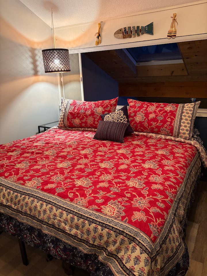 King bed in loft above living room