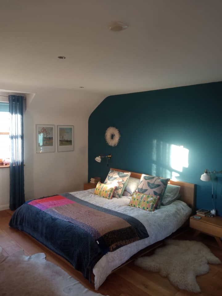 ห้องนอนสวีทขนาดใหญ่ชั้นบนพร้อมเตียงขนาดคิงไซส์และห้องน้ำในตัว