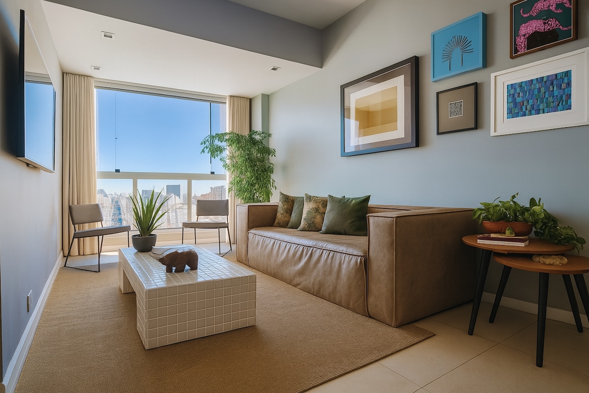 An inviting living area features a modern sofa, a coffee table with geometric design, and seating for two. Large windows provide ample natural light and showcase views of the surrounding city. Artwork adorns the walls, and plants add a touch of greenery.
