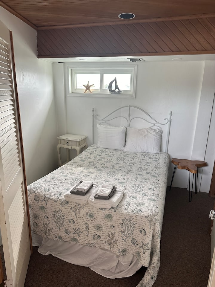 Chumba kidogo cha kulala kilicho na kitanda cha watu wawili, kilicho kwenye nyumba ya boti juu ya maji