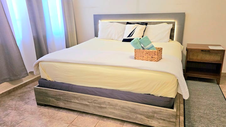 Dormitorio tamaño king en una habitación muy espaciosa con vestidor, baño tipo spa, TV y escritorio. 