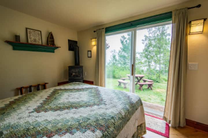 Habitación con vista al lago
¿Cómo puede haber algo mejor que esto? Imagínate acostado en la lujosa cama queen leyendo un buen libro a la luz de la estufa de gas. Cuando miras por la puerta del patio, en la cabaña n.º 2, tienes el lago Superior frente a ti.