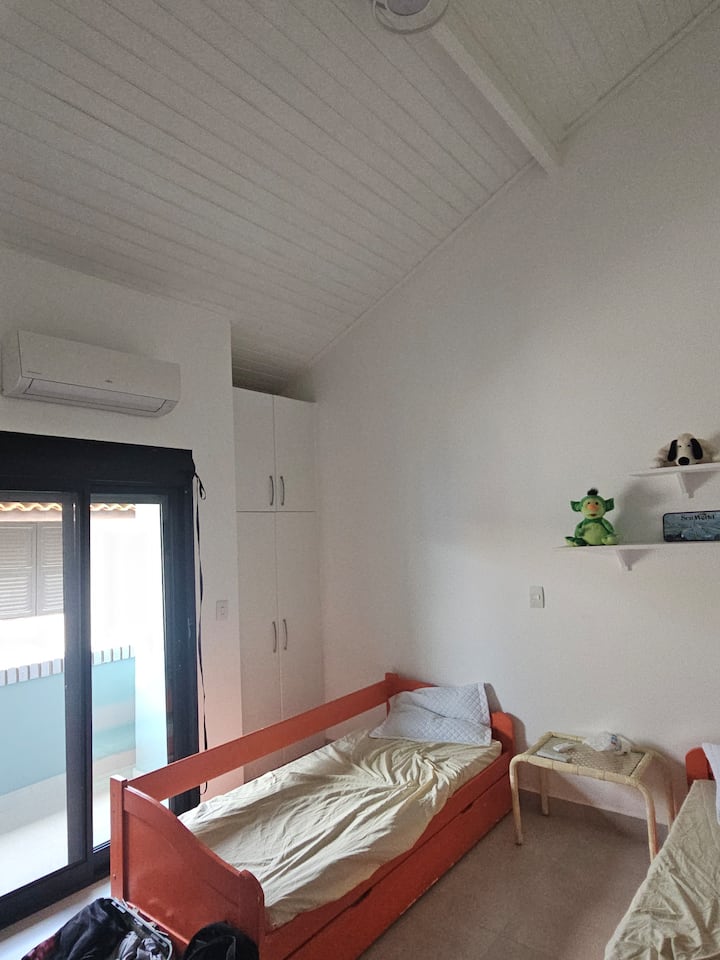 Habitación en suite con balcón, aire acondicionado y armario.