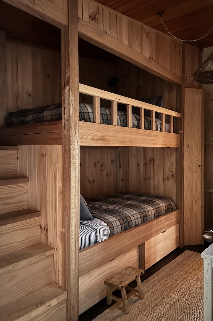 Hand crafted timber bunks. Single x 2. Natural bedding: latex and wool pillows, wool duvet, wool blanket. Staircase to top bunk. Sky light with blind. Large storage cupboard.  Sleep guard rail for bottom bunk available on request.