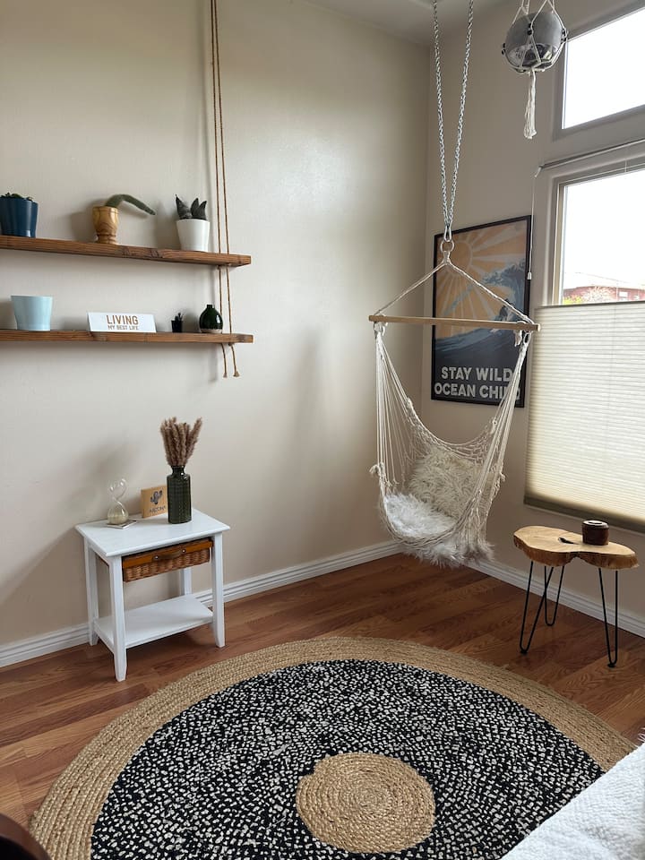 波西米亚风格的卧室，配备矮床和有趣、放松的秋千椅