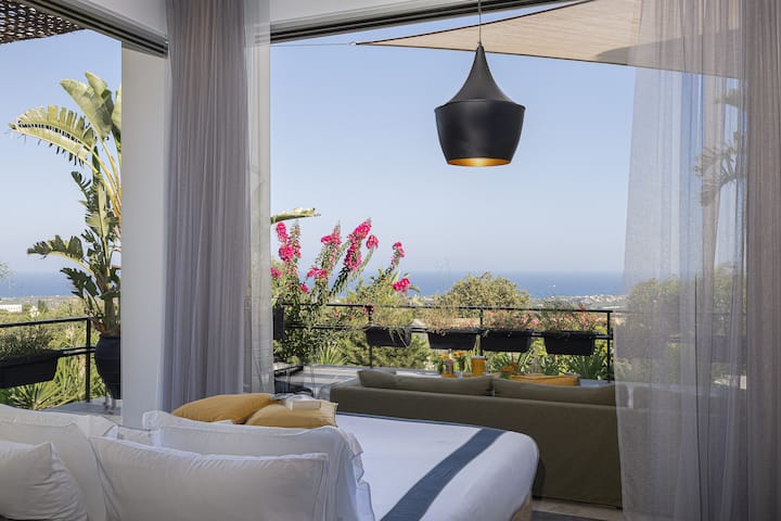Bedroom in lower floor of the main building with a king-size bed and a private veranda.