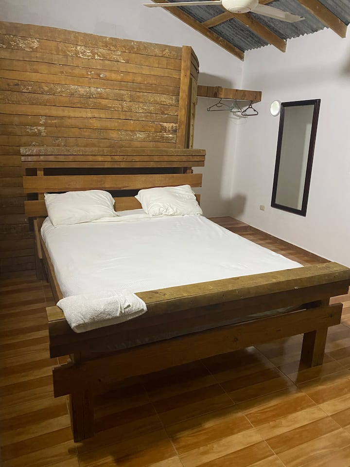 Komfortables Zimmer mit Ventilatoren und sauberer Bettwäsche und Handtüchern.