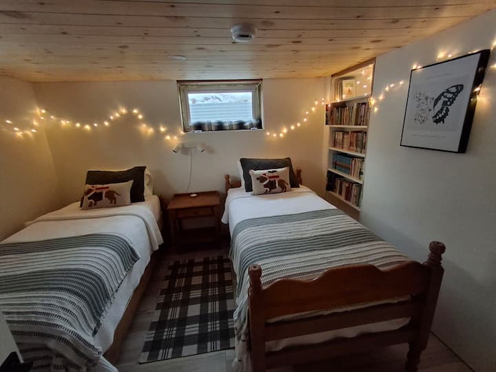 ห้องสวีทห้องนอนส่วนตัวชั้นล่างพร้อมเตียงเดี่ยว 2 เตียง ห้องพักมีห้องสุขาพร้อมอ่างล้างหน้าในตัว!  มีโต๊ะกลางคืนพร้อมช่องเสียบ USB สำหรับชาร์จอุปกรณ์ ตู้เสื้อผ้าขนาดเล็กพร้อมลิ้นชักและตู้ขนาดเล็กสำหรับแขวนเสื้อผ้า