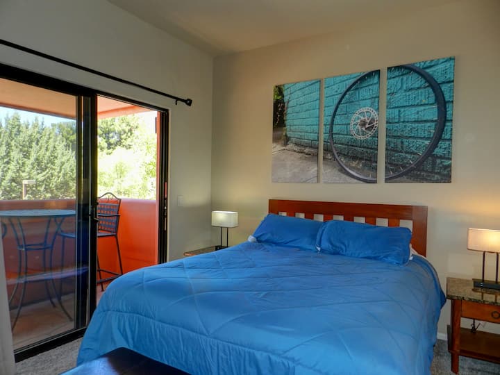 Bright bedroom with a queen bed, fresh linens, and direct patio access for morning light and fresh air.