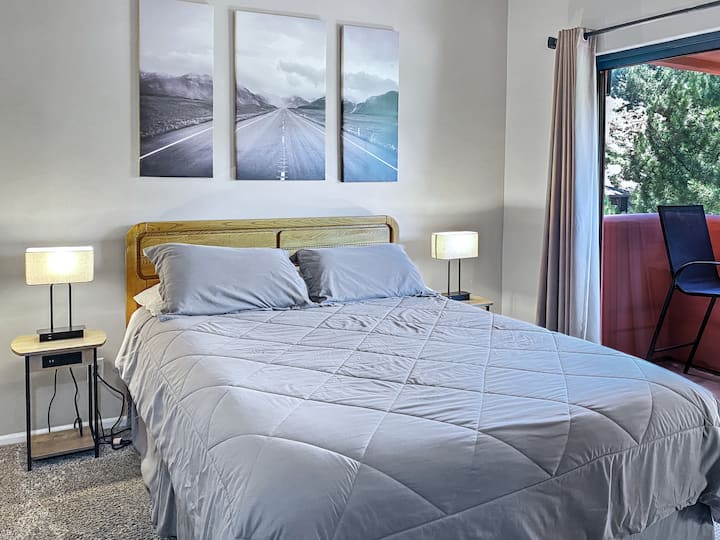Bright second bedroom with a comfortable queen bed, clean linens, and peaceful natural light.