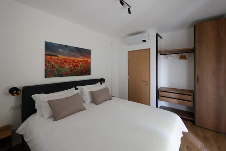 Zimmer mit King-Size-Bett, Klimaanlage, Schrank, Smart-TV und eigenem Bad.
Camera con letto king size, aria condizionata, armadio, smart TV e bagno privato.
Chambre avec lit King Size, climatisation, armoire, télévision connectée et salle de bain privée.