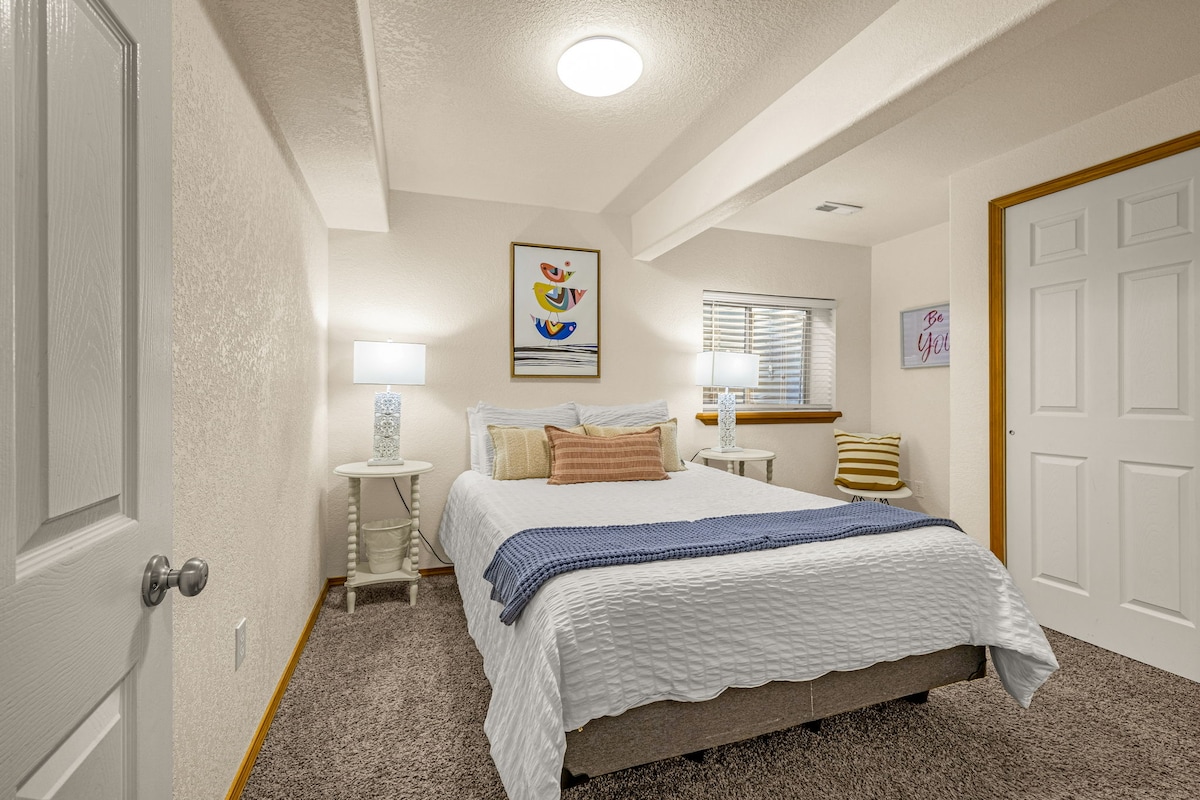 Lower level bedroom with queen bed, a closet, conveniently located near Bathroom 2 in the same hallway.