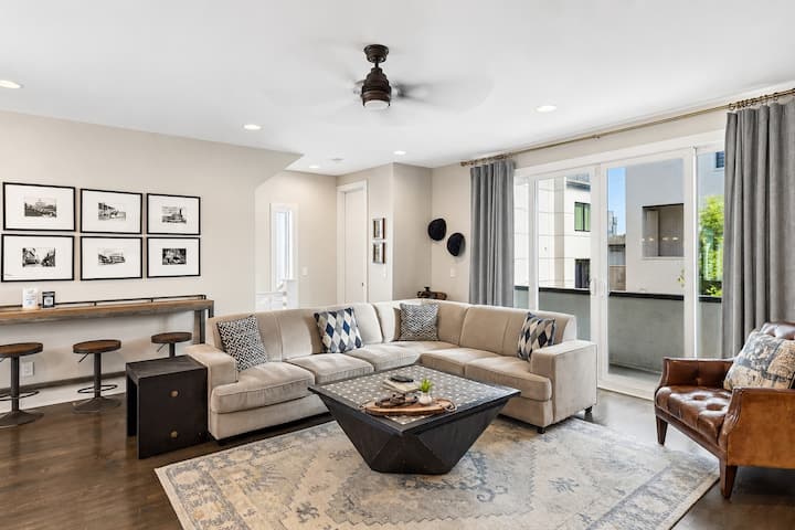 Sink into the tan sectional and let the group decompress — the main living area gives everyone room to spread out without anyone bumping elbows