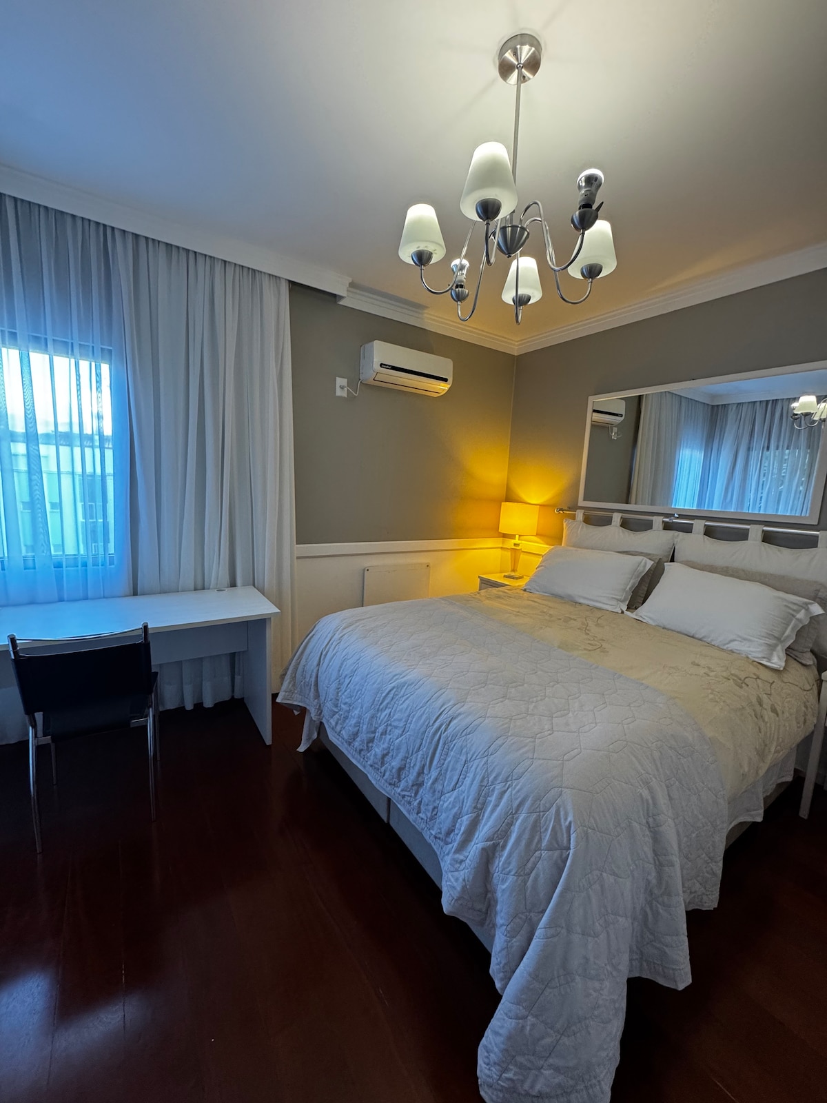 Suite con cama queen, aire acondicionado, calefacción, espacio de trabajo, armarios y balcón. 