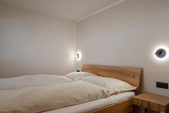 Kleines hofseitiges Schlafzimmer im 1. Stock mit 1.60 m breitem Doppelbett. | Small courtyard-facing bedroom on the 1st floor with 1.60 m wide double bed.