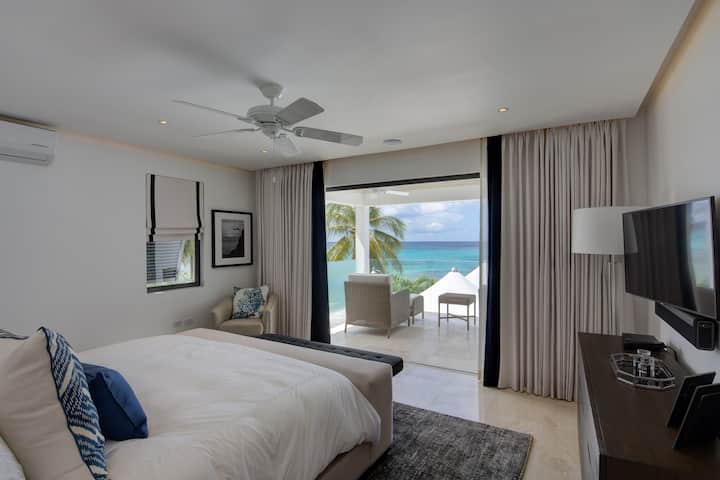 Master bedroom with a king size bed (US), ensuite bathroom, TV, security safe, air conditioning, bath robes, hair dryer and a balcony with sea views.