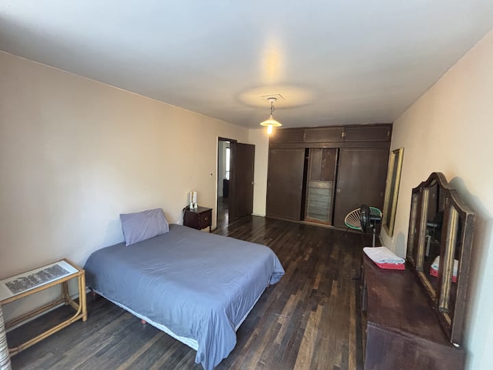 Reacámara 1 con cama matrimonial, grandes ventanas y balcón.